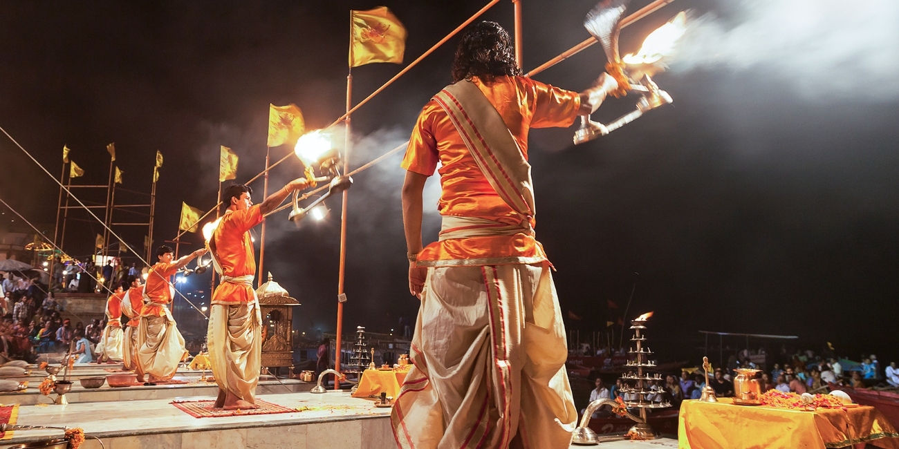 priests performing evening ganga aarti in synchronised movements at Dashashwamedh Ghat
